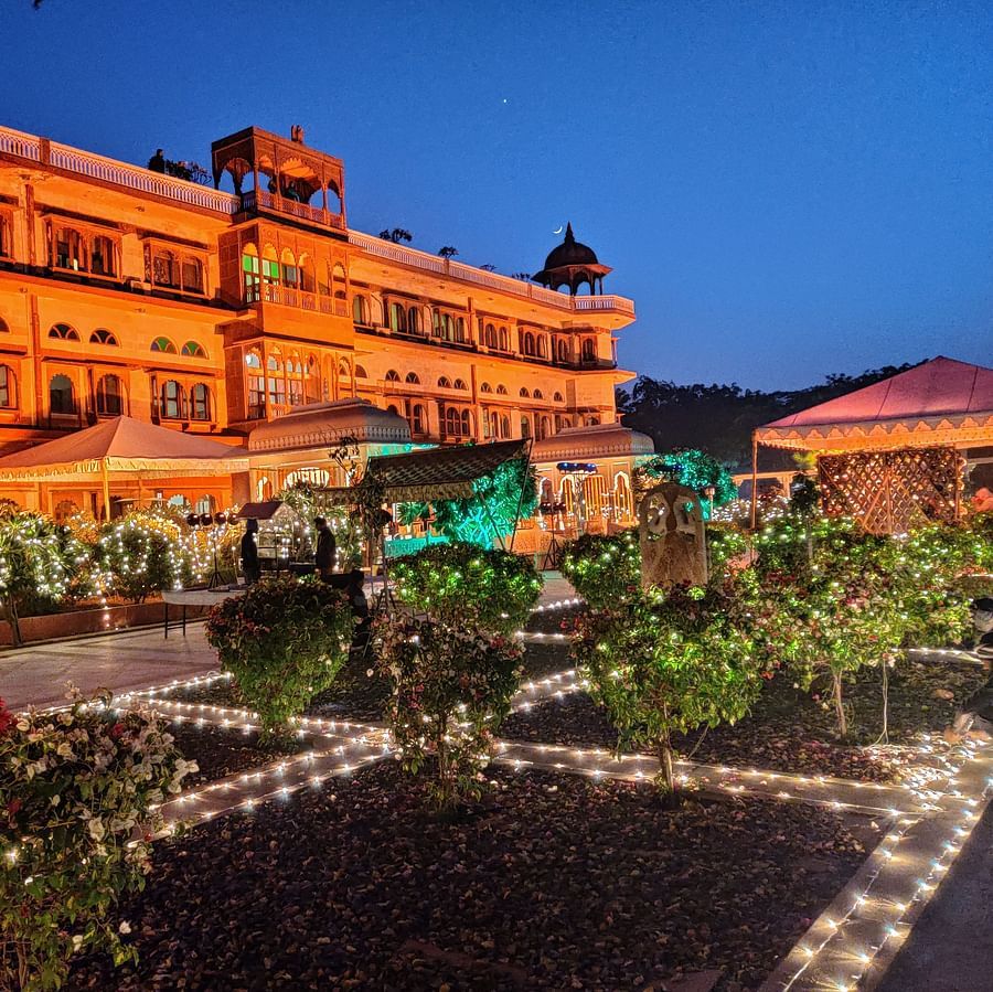Night view of a grand traditional building with a well-lit lawn in the front yard - Umaid Palace - A Lakeside Heritage Palace Resort